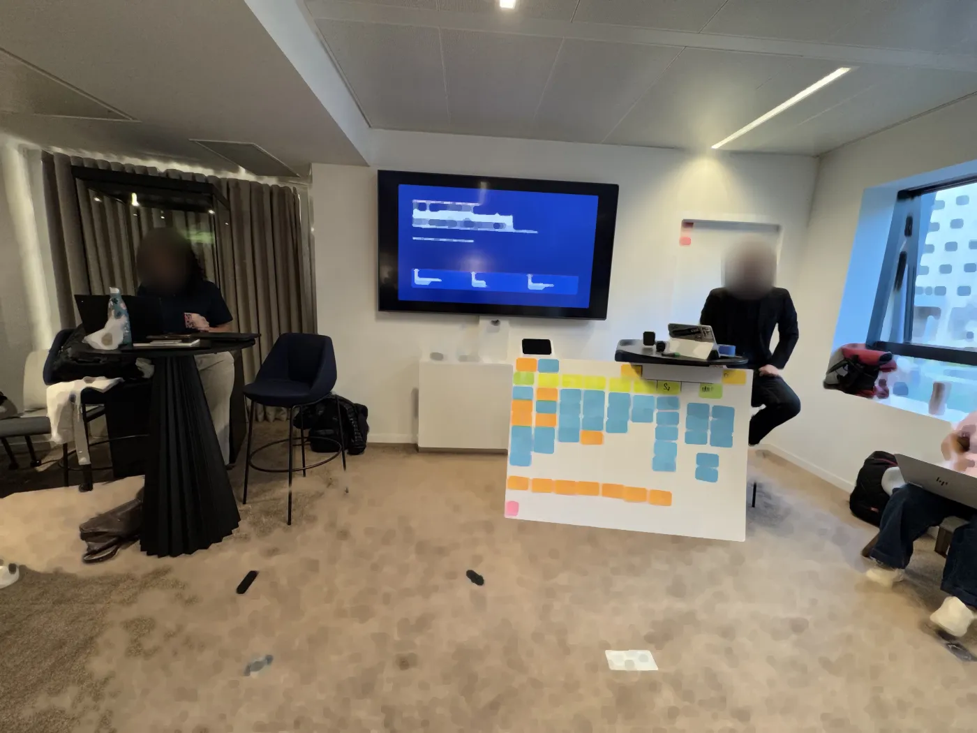A meeting room during PI Planning, a sticky-note board resting on the floor