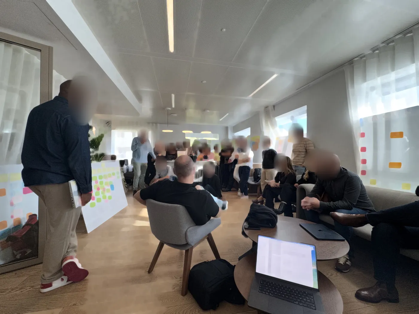 A packed room during PI Planning, teams gathered around their boards
