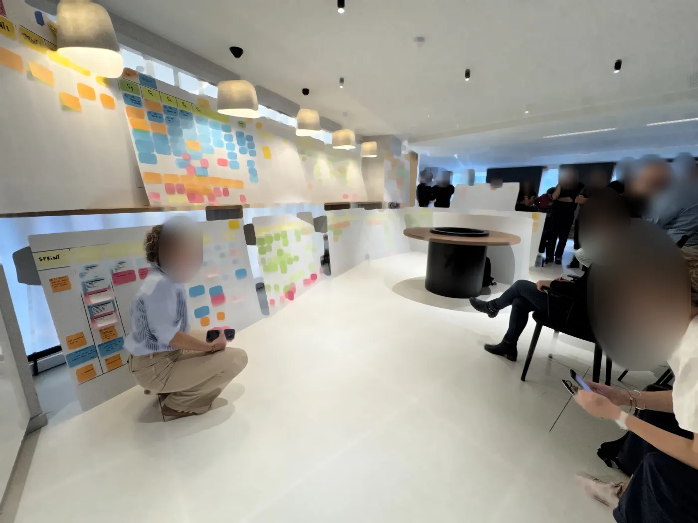 A long wall of boards in a large PI Planning room